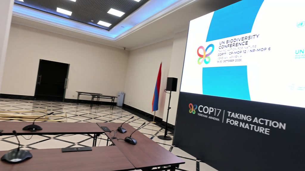 An empty meeting room with an Armenian flag by the wall and a large screen announcing the UN Biodiversity Conference, 19 to 30 October 2026, above the COP17 logo and the words Taking Action for Nature.