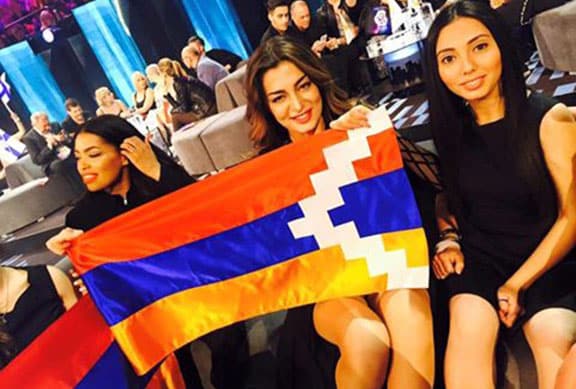 Iveta Mukuchyan displays the Artsakh flag during a Eurovision press conference