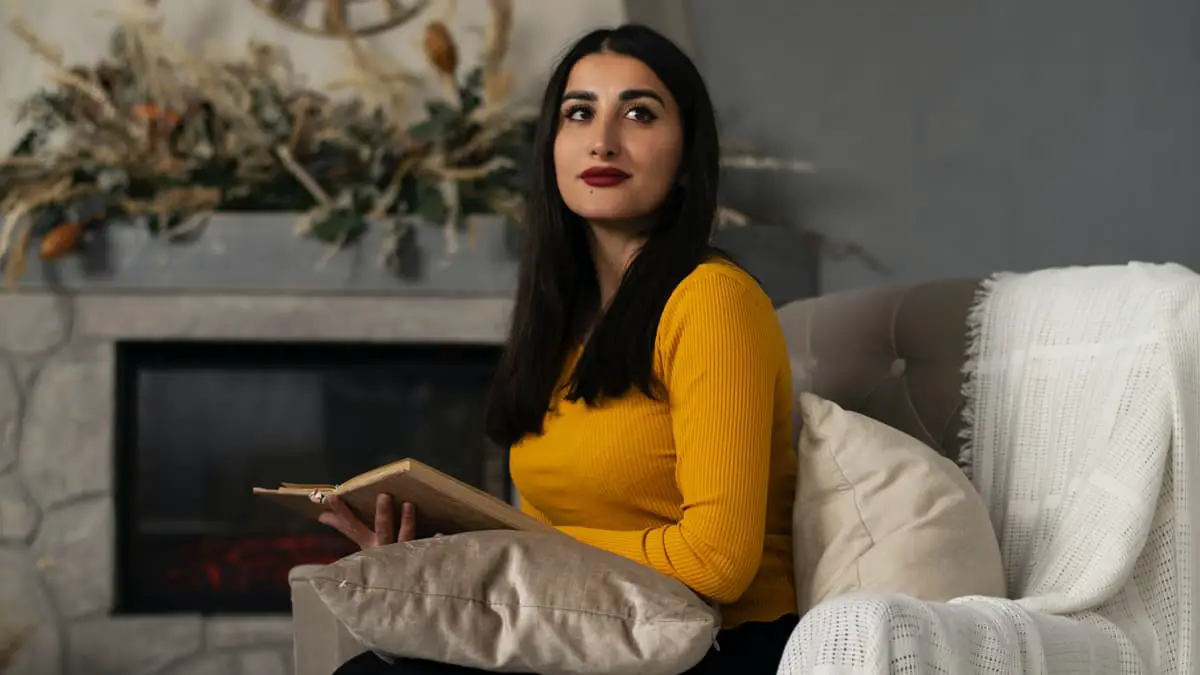 Armenian lady sitting on the couch with a book in her hand