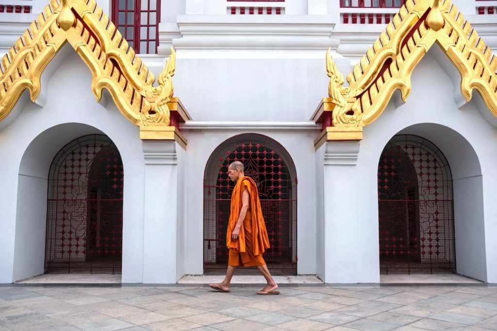 image of a monk walking in front of a building.jpg