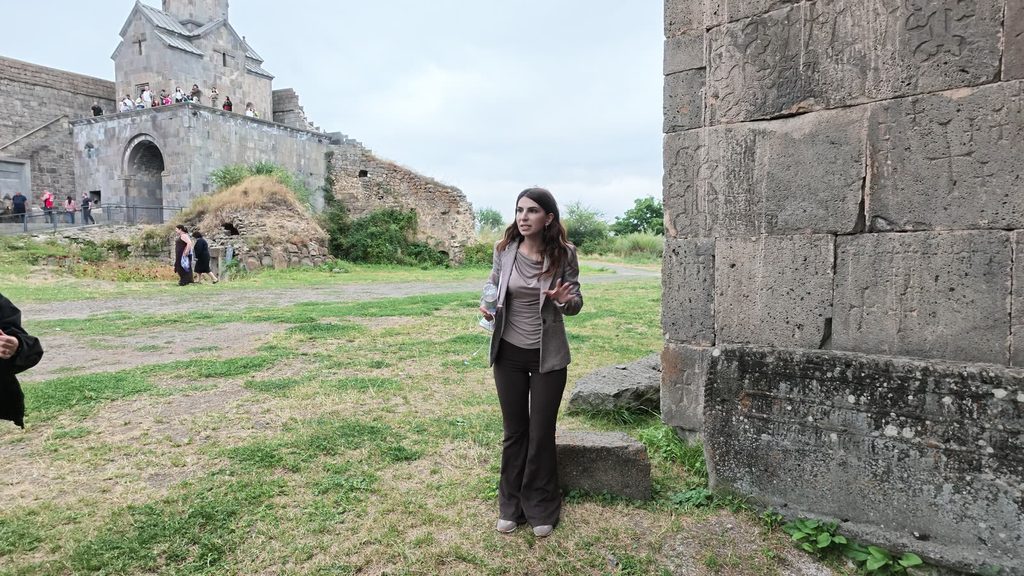 A stone wall at Tatev densely carved with small crosses of different sizes.