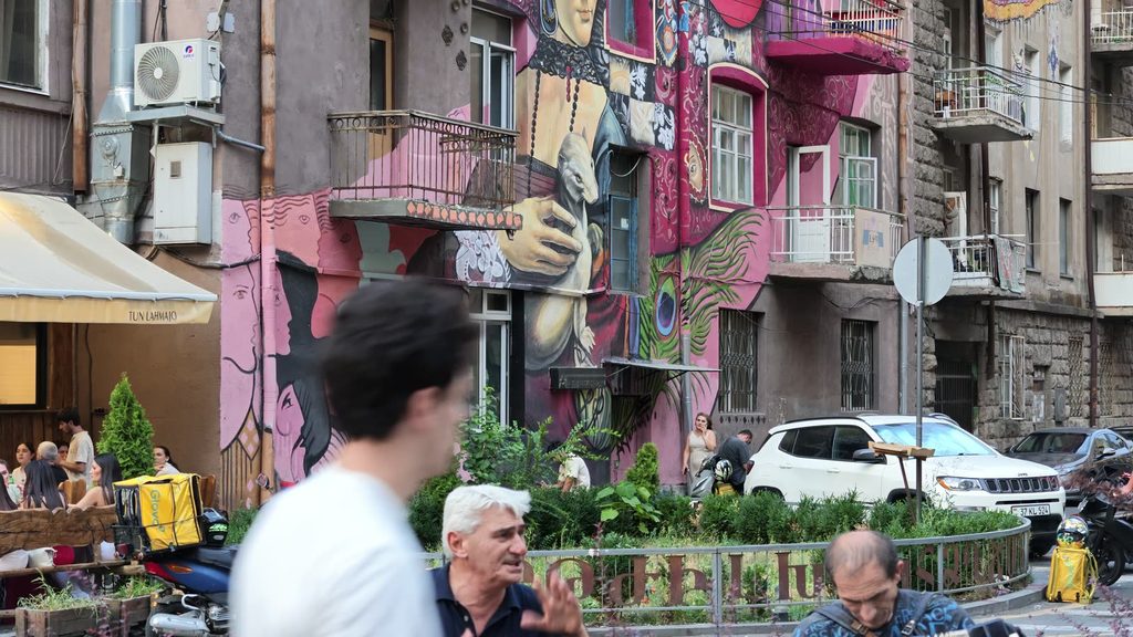 Two buskers on a low wall, one with an accordion and one with a snare drum.