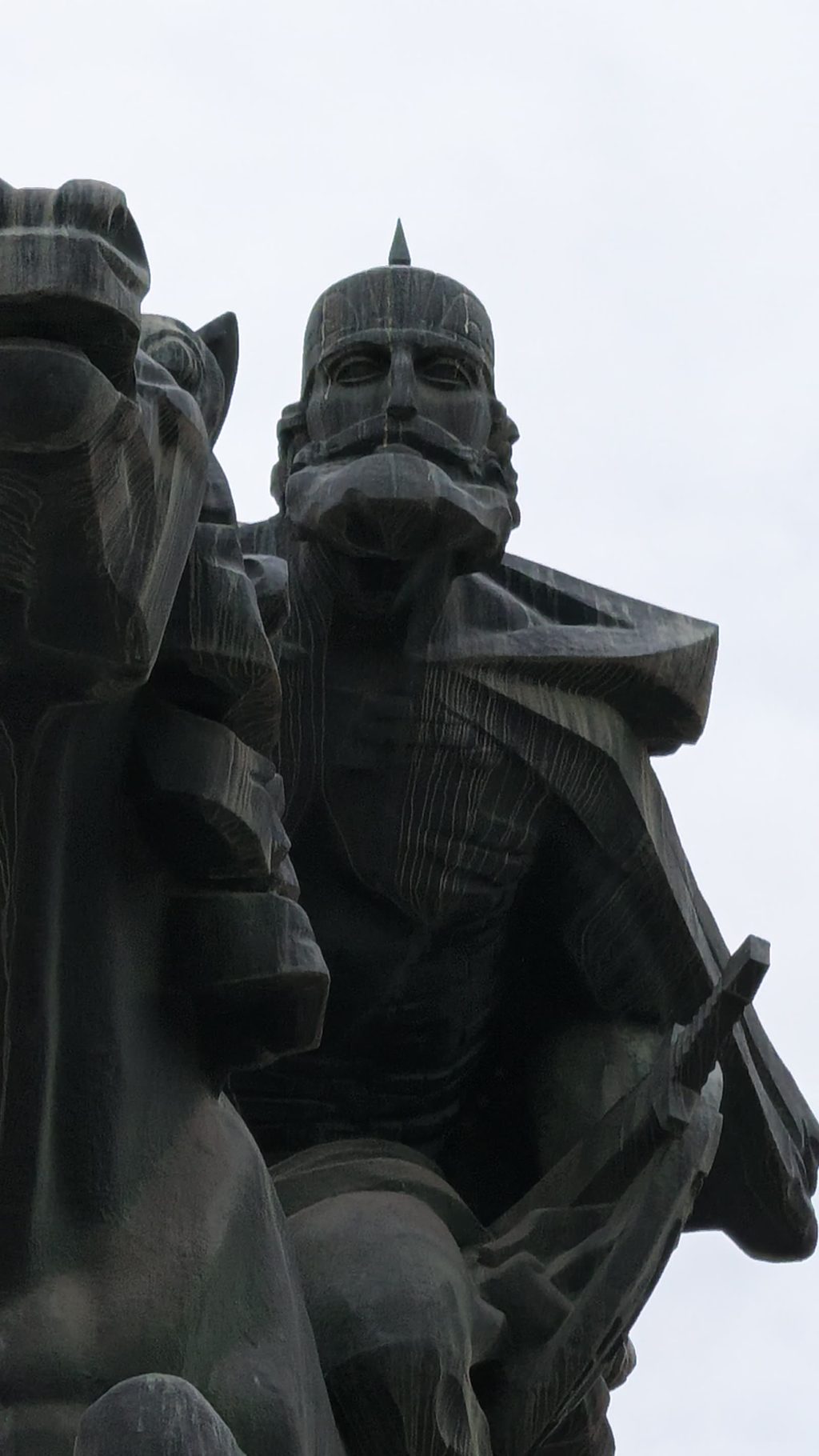 The dark statue of David Bek on horseback, seen from below against a pale sky.